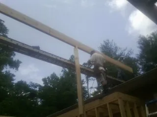 Carpenter setting a ridge beam over a new addition frame — Ice Dam Removal by Roofing Brothers in Chattaroy