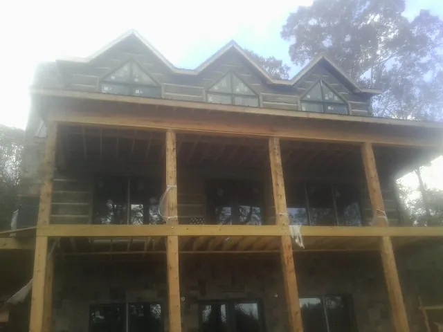 Dormers and porch framing on a large log home under construction — Roof Coating work by our crew in Chattaroy